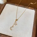 Detailed close-up of an 18k gold plated necklace featuring zircon moon and star pendants - Gold