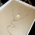 Detail view of a multi-layer gold-toned necklace with enamel flower pendant and pearls - Layered Style / Gold White Yellow