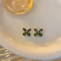 Detailed view of elegant green zircon flower stud earrings on a minimalist ceramic plate - Tops / Silver (Green Zircon)