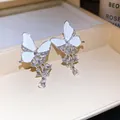 Detailansicht von Schmetterlingsohrringen mit Strasssteinen und tropfenförmigen Quasten. - Silberstift Schmetterling Quaste Stil / Silber/Weiß