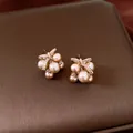 Macro shot of elegant champagne pearl stud earrings with zircon butterfly bow detail - Champagne Gold