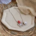 Detailed view of a silver-tone necklace featuring zircon butterfly and white pearl - Silver