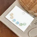Vista detallada de pendientes cuadrados de resina en tonos pastel Morandi sobre tarjeta. - Juego de Marrón Azul y Verde