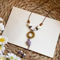 Close-up of Bohemian shell necklace featuring wooden beads and a purple shell pendant - Conch Pendant / Purple