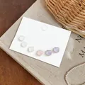 Primer plano detallado de pendientes cuadrados de resina en colores Morandi suaves - Juego de Blanco Rosa y Púrpura