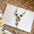 Detail view of Bohemian long necklace with blue heart and star charms on woven background - Starfish Pendant / Blue