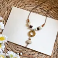 Close-up detail of Bohemian shell necklace featuring mixed beads on a minimalist white background - Scallop Pendant / White