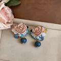 Close-up of French vintage resin flower stud earrings with elegant blue bead charms - French Vintage Studs / Gold-Blue-Pink