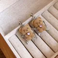 Close-up of flocked teddy bear earrings with angel wings and pink heart zircon. - Earrings / Silver-Coffee