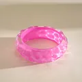 Macro view of the pink resin bangle showing unique pleated wave patterns and glossy finish. - Lavender