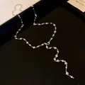Dettaglio di una collana a Y a forma di cuore d'argento con strass scintillanti - Collana / Argento