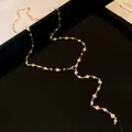 Dettaglio della collana a Y dorata con ciondoli a cuore e strass brillanti lussuosi - Collana / Oro