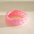 Close-up of vibrant pink iridescent resin bangle with a unique pleated ripple texture - Pink