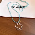 Dettaglio della collana con ciondolo a fiore traforato argento e cordino blu intrecciato - Stile Fiore Cavo / Blu