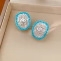 Detailed view of elegant oval hollow earrings with turquoise-colored beads and zircons - Hollow Oval Style
