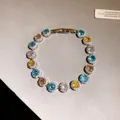 Dettaglio di un bracciale di lusso con zirconi rotondi colorati e montature halo scintillanti - Argento - Arcobaleno