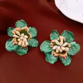 Nahaufnahme von grünen Blumenohrringen mit Goldakzenten und weißen Stempeldetails. - Grün