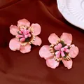 Nahaufnahme eleganter rosa Emaille Blumenstecker mit Goldakzenten auf braunem Stoff - Rosa