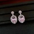 Detaillierte Makroansicht von ovalen Ohrhängern mit rosa Zirkonia und Glitzereffekt - Hängeohrringe / Rosa
