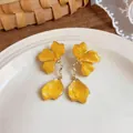 Detailed view of elegant yellow enamel floral drop earrings with gold-toned metal accents - Yellow