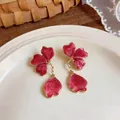 Detailed view of elegant red enamel flower drop earrings with a gold-tone metal finish - Rose Red