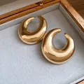Dettaglio macro di orecchini a lobo dorati lucidi a forma di mezzaluna in scatola - Oro