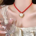Red cord necklace featuring a gold heart pendant with a delicate white daisy flower - Gold-White-Red