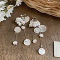 Detailed macro view of French vintage clip earrings with baroque faux pearls and shell discs. - Clip-On Earrings / White