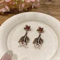 Close-up detail of vintage palace style fish tail earrings with white pearls and red stones - Fish Tail Pearl Drop Style (HE33491 HE33754) / Antique Gold-Pink
