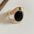 Elegante bracciale rigido dorato geometrico traforato con grande pietra ovale nera - Stile Plissettato con Gemma Nera / Oro