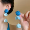 Detailed macro view of elegant blue hydrangea floral petal tassel earrings on model - Silver Earring Post Style / Blue
