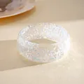 Macro detail of a translucent iridescent resin bangle with holographic foil flakes texture - White