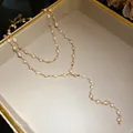 Detail view of gold-tone double-layered necklace with white beads in a jewelry box - Eco-friendly Style / Gold, White
