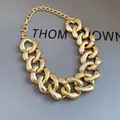 Detailed view of chunky gold-plated adjustable chain necklace on grey textured box - Gold Chunky Chain Choker / Gold