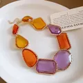 Gros plan d'un collier de style royal vintage avec des pierres précieuses en résine - Collier / Patchwork Violet Jaune Café