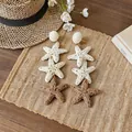Detailed view of three-tier raffia star drop earrings for a summer vacation look - White-Coffee