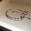 Close-up of 18K gold plated bangle with hollow geometric design and stones - Hexagonal Geometric Hollow Style