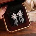 Elegante silberne Blumen-Ohrstecker mit feinen langen Quasten in einer Schmuckschatulle - Silber