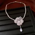 Detailed macro view of a silver-toned flower necklace with zirconia and teardrop crystal - Necklace Only (Without Bracelet) / Silver