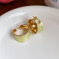 Dettaglio macro di eleganti orecchini a cerchio placcati oro 18k con smalto verde chiaro - Placcato in Oro Vero 18 carati (HE32080) / Oro con Verde