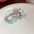 Dettaglio ravvicinato di orecchini a cerchio in smalto celeste con trama placcata oro - Placcato in Oro Vero 18 carati (HE32080) / Argento & Blu