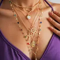 Close-up of layered gold necklaces featuring sun, cross, and religious icon charms - 6-Piece Set / Gold