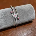 Close-up of a silver-tone flower bangle with sparkling pink and clear zircons on display - Floral Bangle (3)