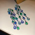 Gedetailleerde weergave van elegante kwastjesoorbellen met groene en blauwe zirkonia druppels. - Zilver-Groen-Blauw