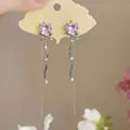 Détail de boucles d'oreilles cœur rose avec nœud argenté et longues franges. - Style Cœur Gland Nœud Papillon / Rose-Argent