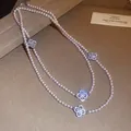Detailed view of elegant pearl necklace with sparkling zircon clover charms. - Necklace / Silver