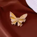 Detailed macro shot of 18k gold plated butterfly brooch encrusted with sparkly crystals - Gold