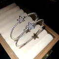 Primo piano di orecchini a cerchio a stella in argento con strass scintillanti - Argento