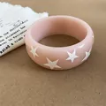 Bracelet jonc en résine rose avec motifs étoiles blanches sur fond texturé - Rose Clair
