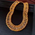 Exquisite gold-tone tiered necklace with pleated bar details on a jewelry display tray - Necklace / Gold